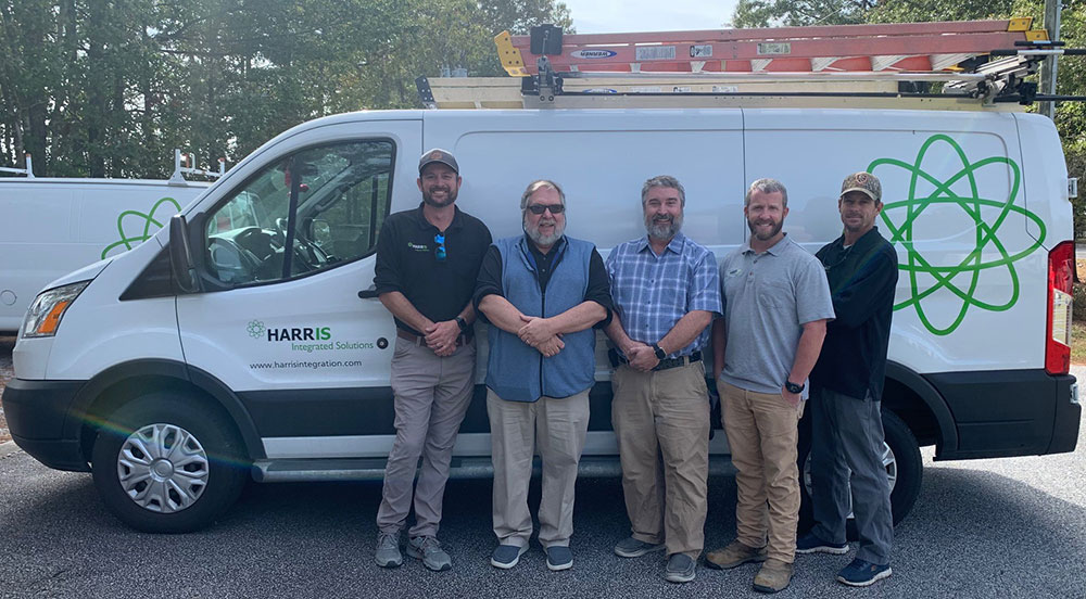 Faculty and HVAC employees in front of a company van