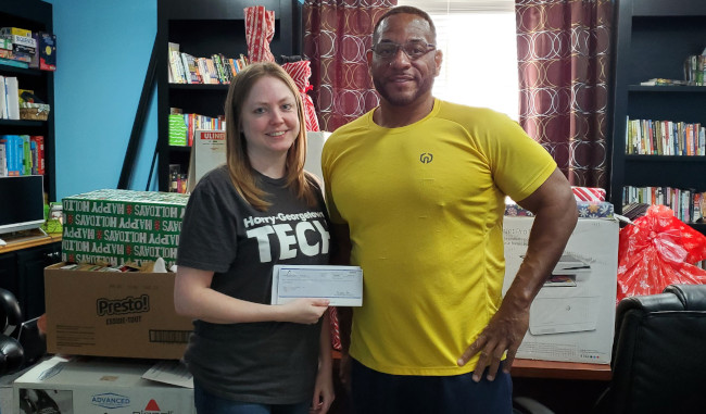 Kari Royals (left), HGTC Administrative Assistant for Academic and Workforce Development, presents $1,175 check to Jay Pratt (right), Executive Director for The Waccamaw Youth Center.