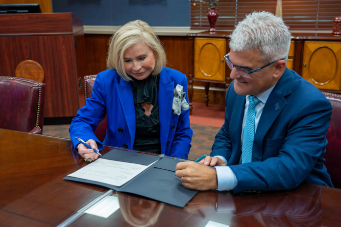 Horry-Georgetown Technical College President Dr. Marilyn “Murph” Fore (left) and Coastal Carolina University President Dr. James Winebrake (right) sign a transfer agreement establishing a new business pathway between the two institutions.